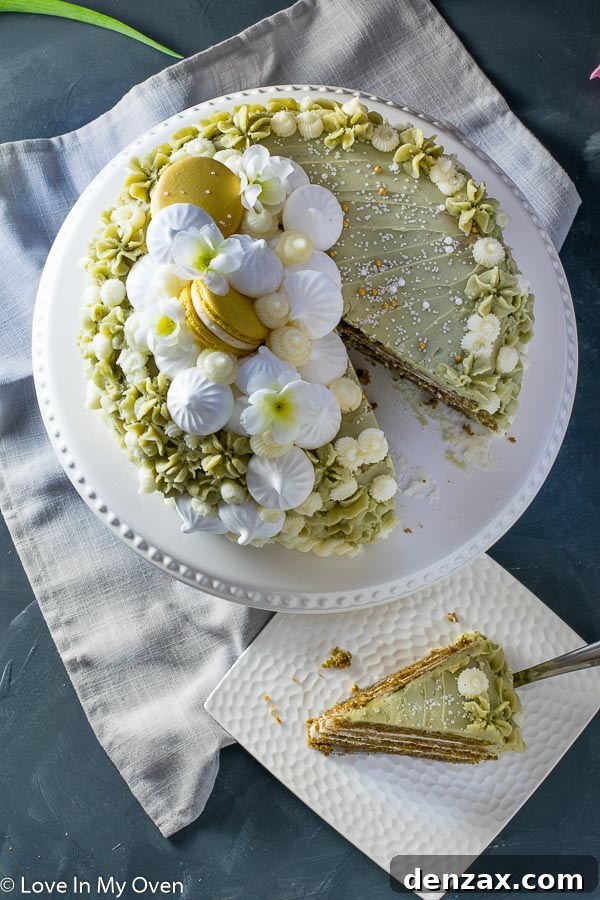 A beautifully decorated Matcha Vanilla Cake with a delicate floral garnish.