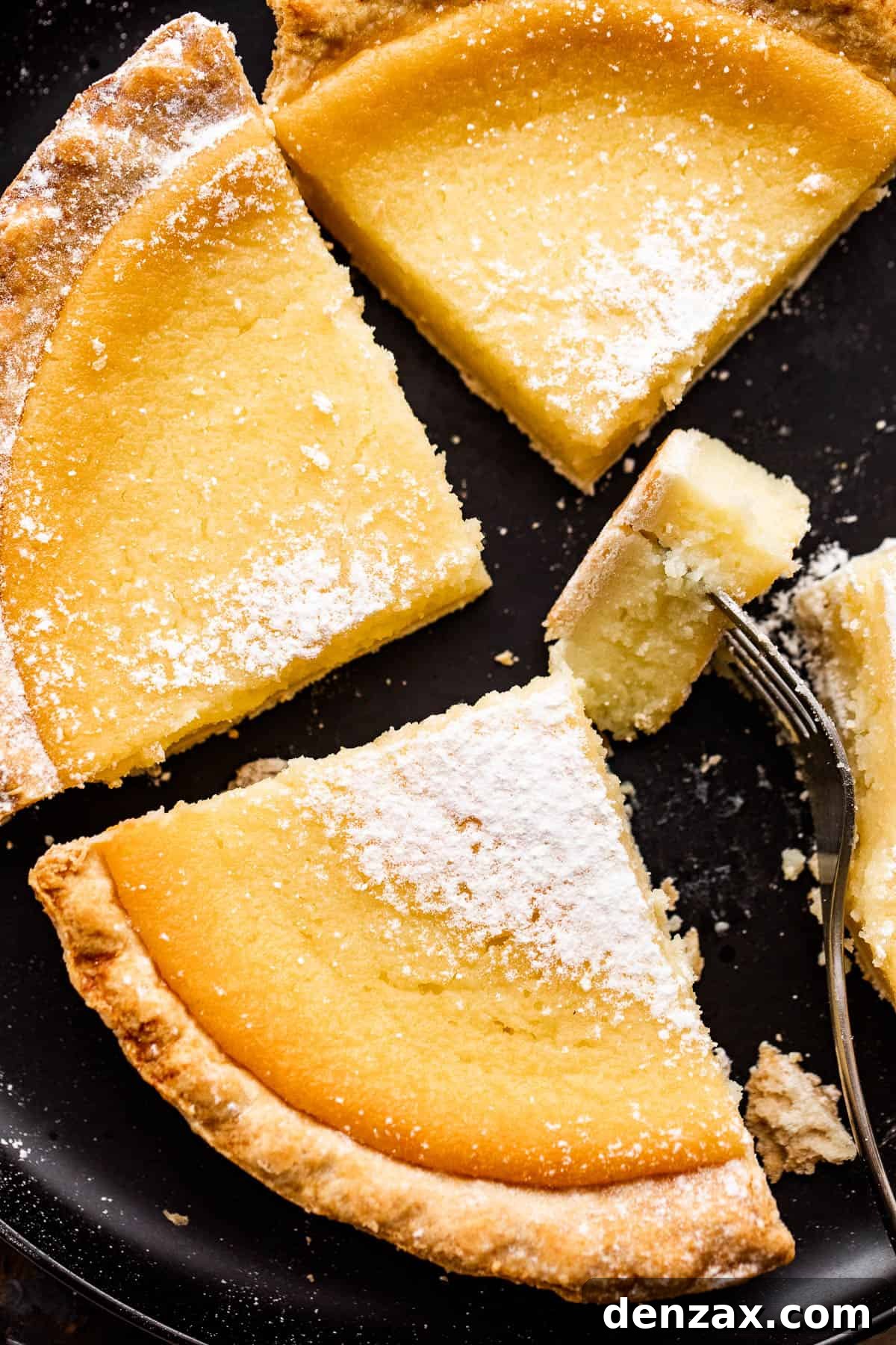A close-up view of a slice of Southern Buttermilk Pie, showcasing its creamy, smooth custard filling and golden-brown, flaky crust.
