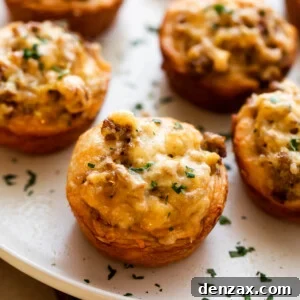 Close-up shot of individual baked sausage breakfast cups, garnished with parsley.