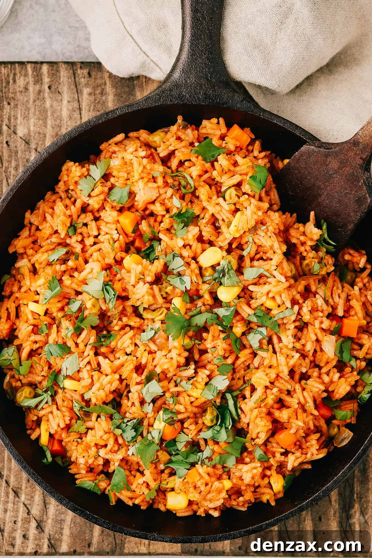 Instant Pot Fiesta Rice 2 Overhead shot of a pan of spanish rice with a wooden utensil in the pan.