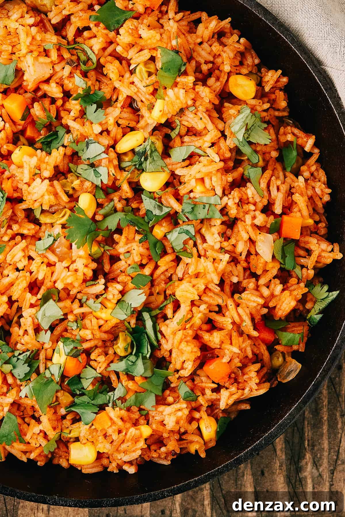 Instant Pot Fiesta Rice 8 Close-up shot of a pan of seasoned rice and vegetables, garnished with fresh herbs.