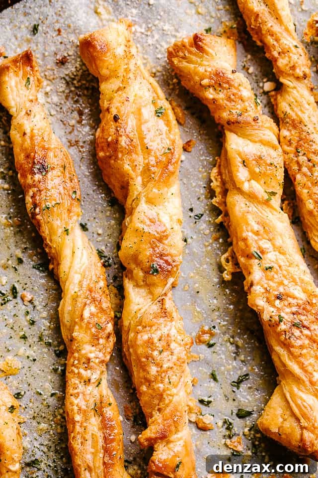 Puff pastry cheese sticks fresh out of the oven on their baking sheet.