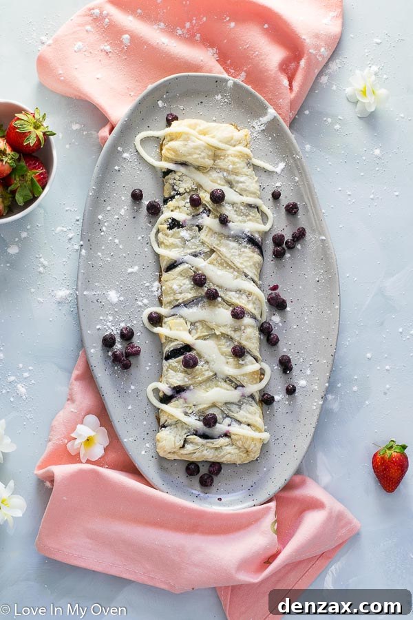 Delicious homemade blueberry strudel, golden brown and glistening with a sweet glaze, perfect for a cozy treat or special occasion.