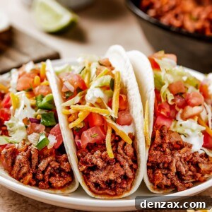 Two tacos on a small white plate, ready to be eaten.