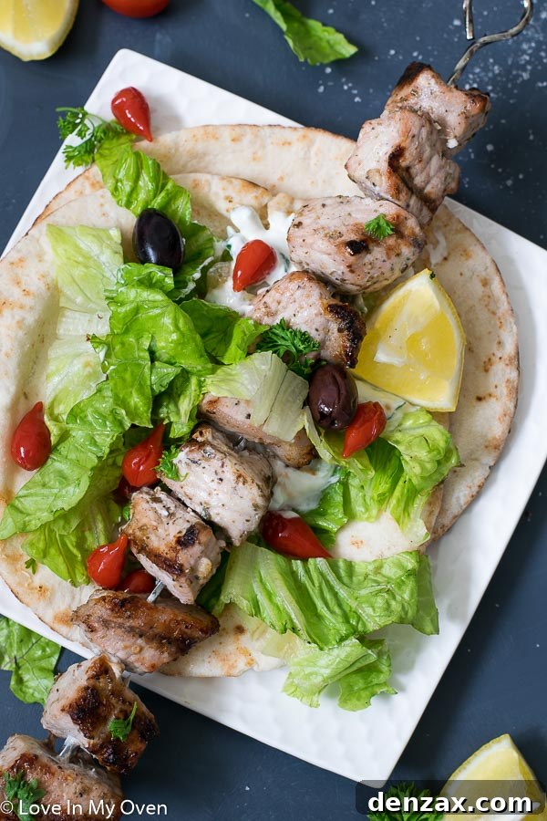 Freshly grilled pork souvlaki on a platter, garnished with lemon