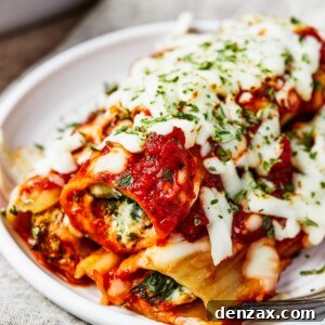 Close-up shot of three stuffed manicotti shells on a small plate, beautifully presented.