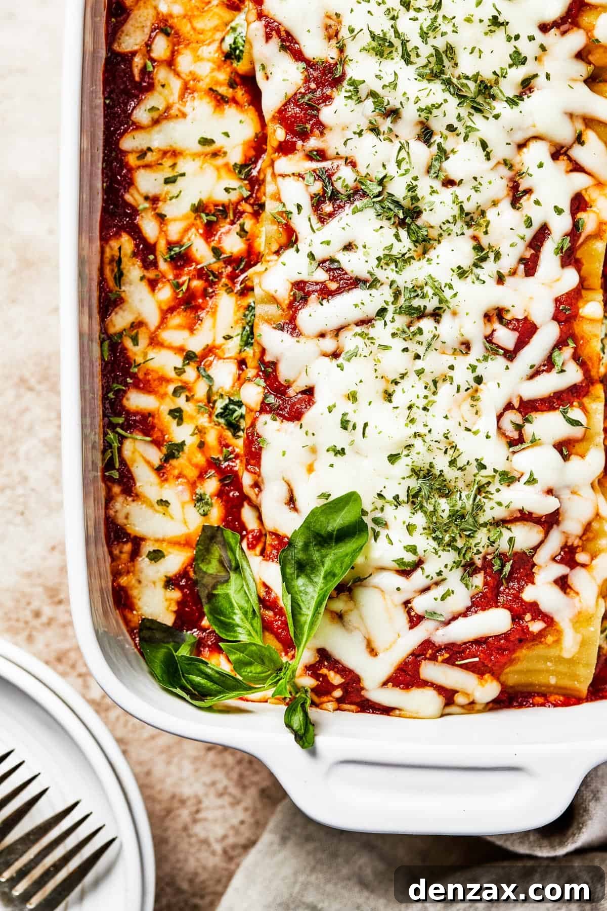 A pristine white baking dish filled with a baked pasta, showcasing a rich marinara sauce and perfectly melted cheese, ready to be served.