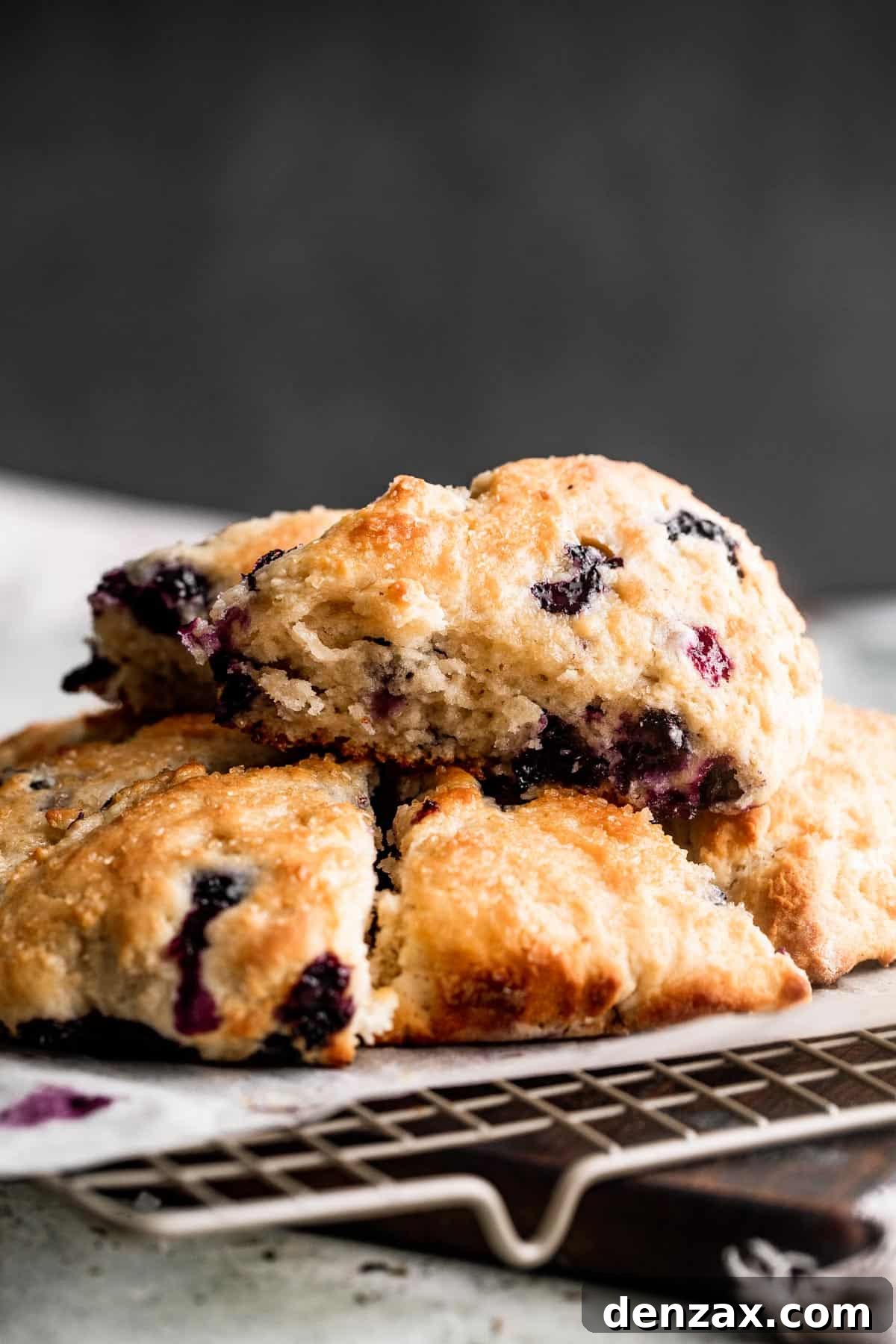 three blueberry scones set on a wire rack