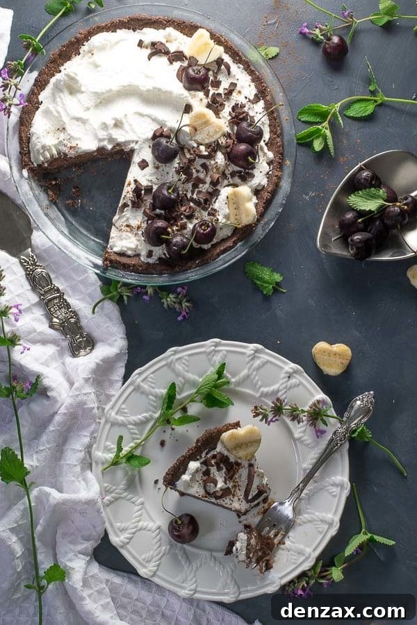 Two slices of chocolate nice cream pie on white plates, with one slice slightly angled to show the layers.