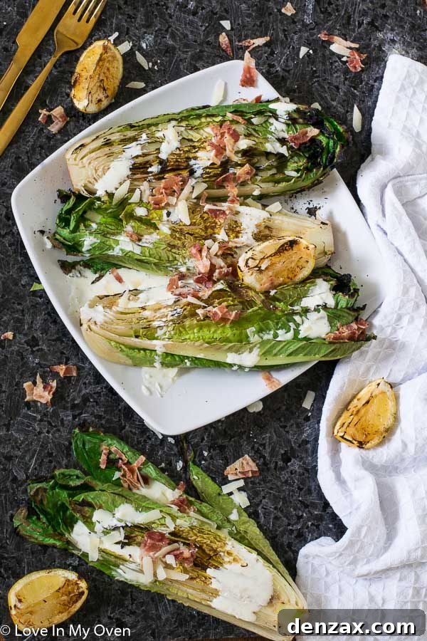 A beautifully plated grilled romaine Caesar salad with visible char marks on the lettuce, drizzled with creamy dressing, and topped with parmesan and bacon bits.