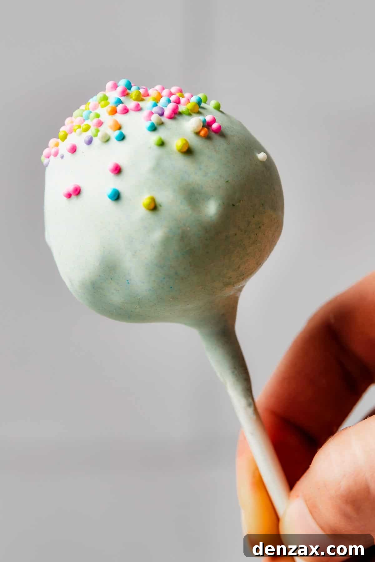 A beautifully decorated pastel-colored cake pop with vibrant sprinkles, showcasing its perfect form and texture.