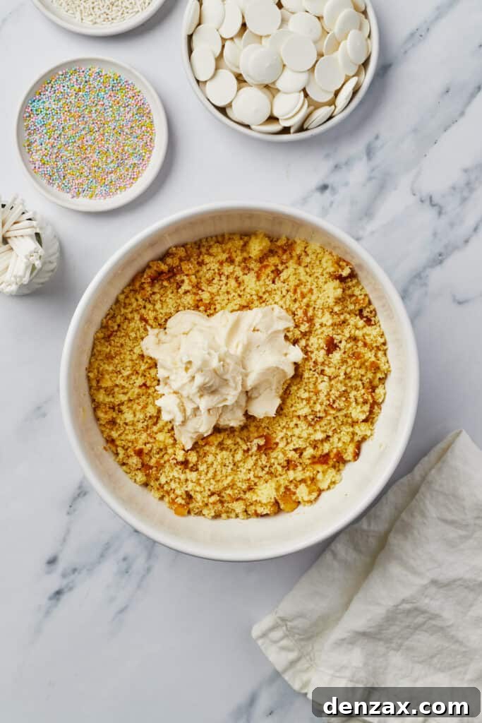 A close-up of cake crumbs thoroughly mixed with frosting in a bowl, creating a moldable dough.