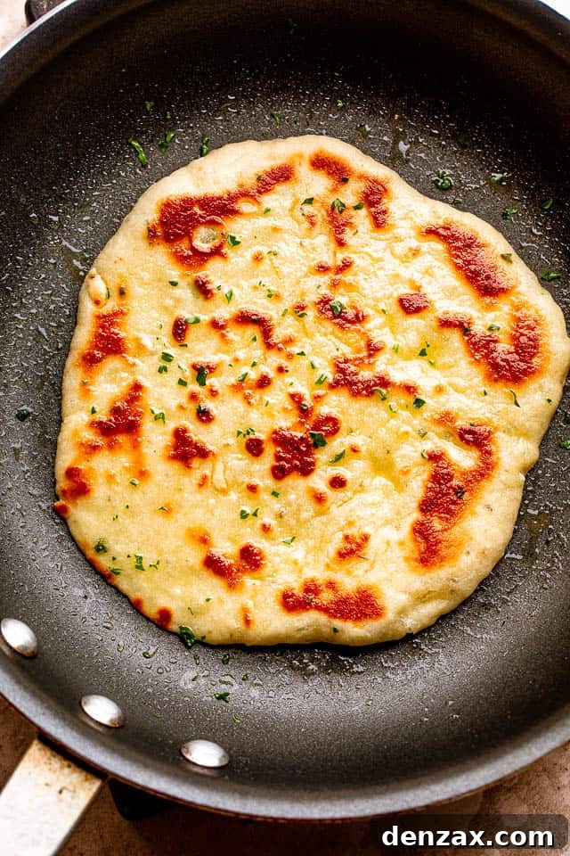 Golden-brown homemade flatbread cooking in a hot skillet, bubbling beautifully.