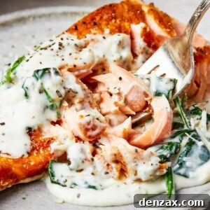 Creamy Florentine Salmon 12 A serving of salmon florentine. A bite of the salmon is being lifted toward the camera on a fork.