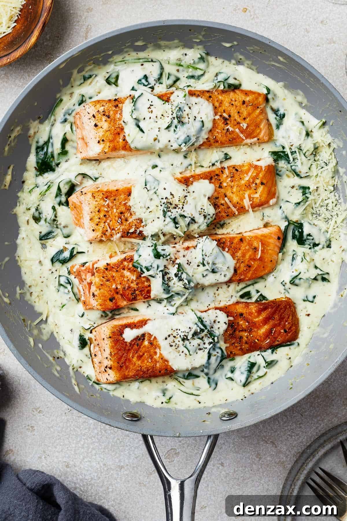 Creamy Florentine Salmon 9 Salmon fillets in creamy spinach sauce in a gray nonstick skillet.