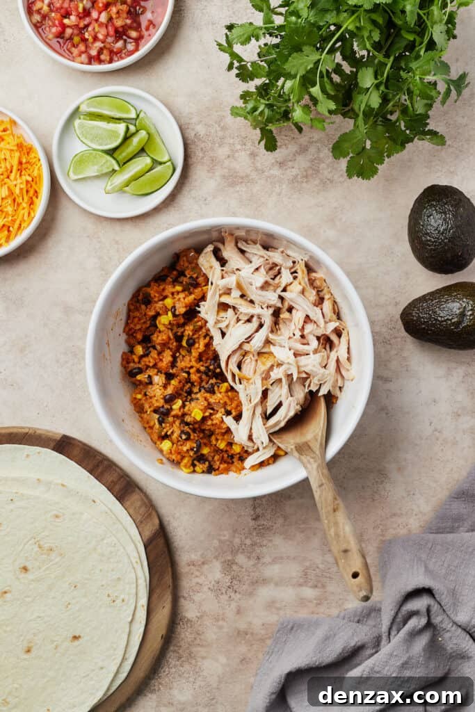 A white serving dish filled with the rich, cooked Instant Pot chicken burrito mixture, showing off the tender chicken, vibrant corn, and black beans. A wooden spoon rests invitingly in the dish.