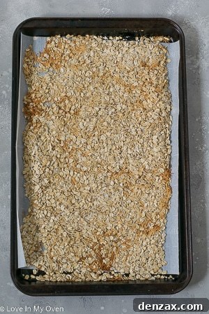 A mixture of oats, coconut, and M&M's ready for pressing into a pan