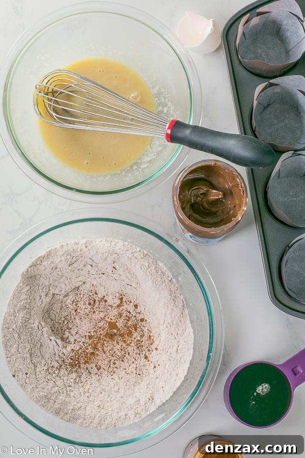 Preparing the muffin batter, showing the dry ingredients mixed with wet ingredients before the Nutella swirl.