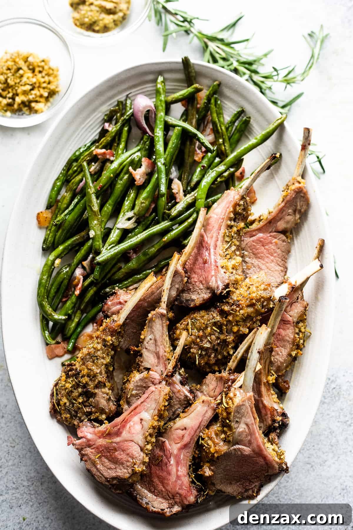 overhead shot of lamb chops arranged on a serving platter with a side of green beans placed above the chops.