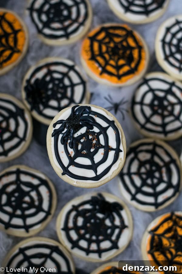 A close-up shot of a cream cheese cookie decorated as a festive pumpkin for autumn.