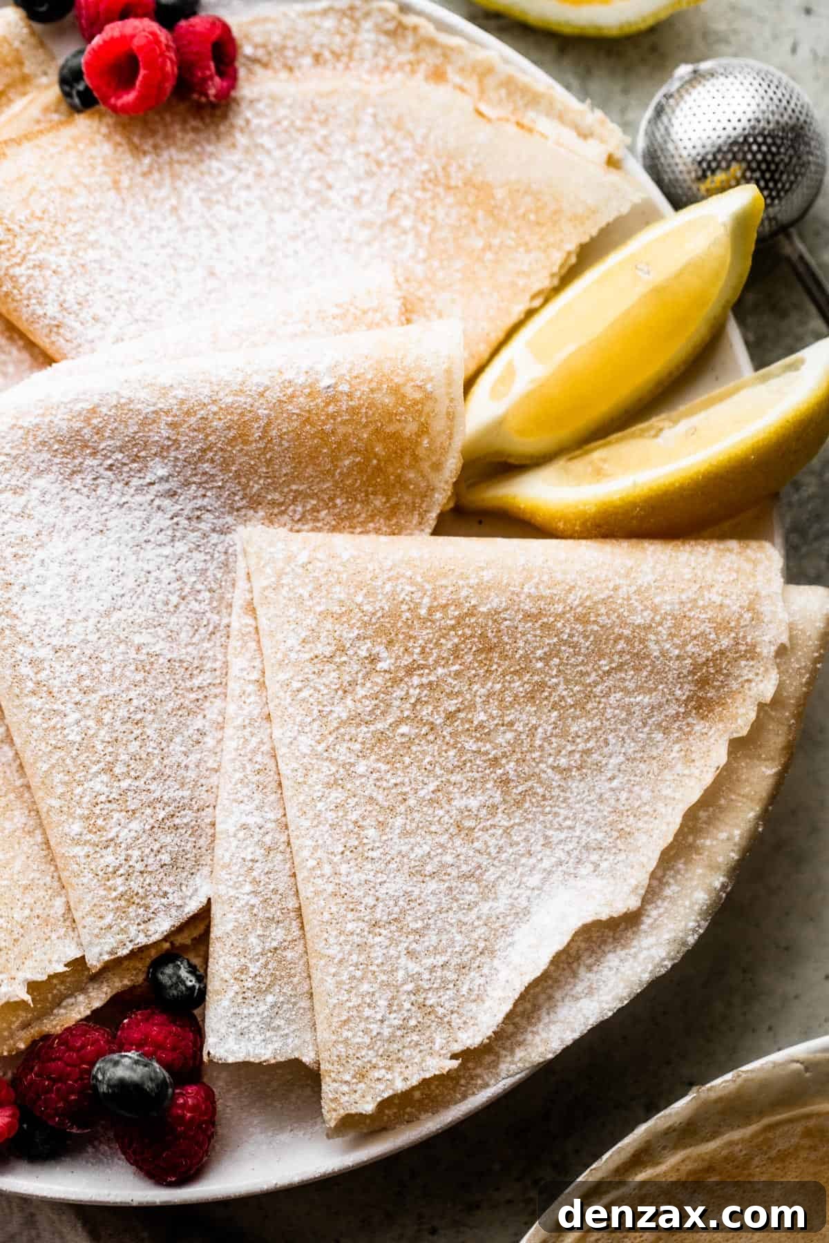 overhead shot of three folded crepes dusted with powdered sugar