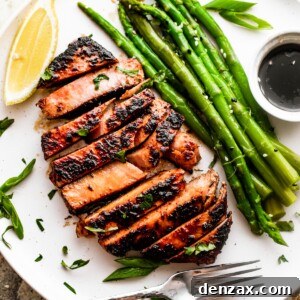 Blackened Tuna Steaks with Balsamic Drizzle 2 wide overhead shot of a white dinner plate with a sliced tuna steak, asparagus stalks, soy dipping sauce, and a lemon wedge.