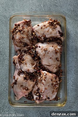 Close-up of marinated chicken thighs ready for roasting.