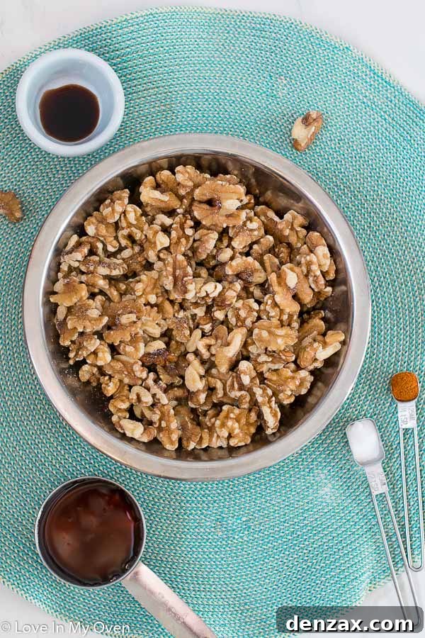 Ingredients for healthy candied walnuts laid out on a table, including walnuts, maple syrup, and spices.