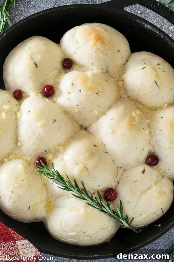 Close-up of golden brown garlic butter dinner rolls on a wooden board, showcasing their fluffy texture.