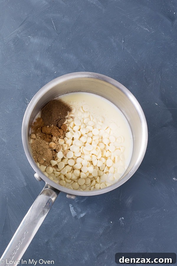 A selection of gingerbread ingredients, including condensed milk, white chocolate, and ground spices, arranged on a surface.