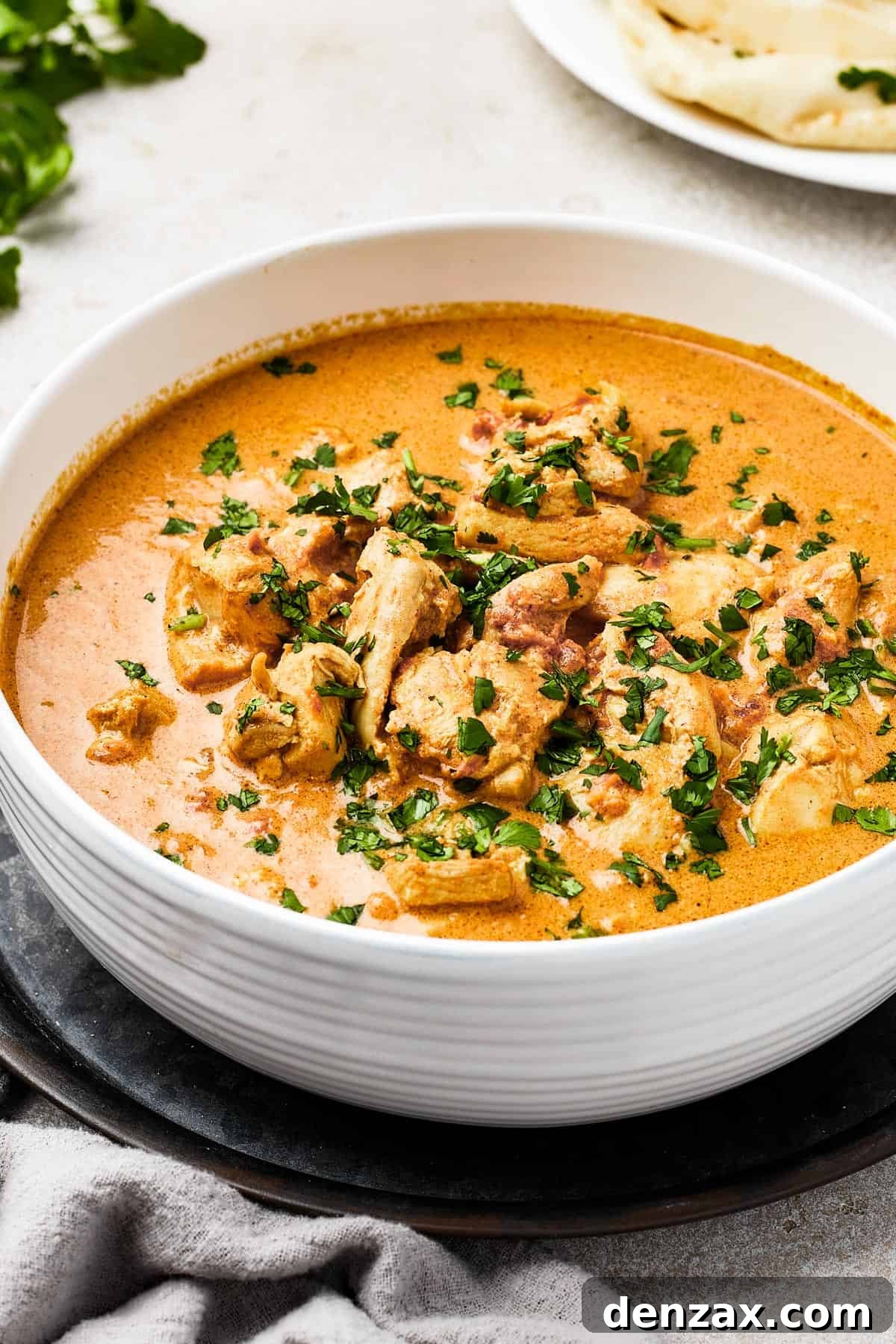 Butter Chicken Makhani 2 Indian Butter Chicken in a white enamel bowl, garnished with cilantro.