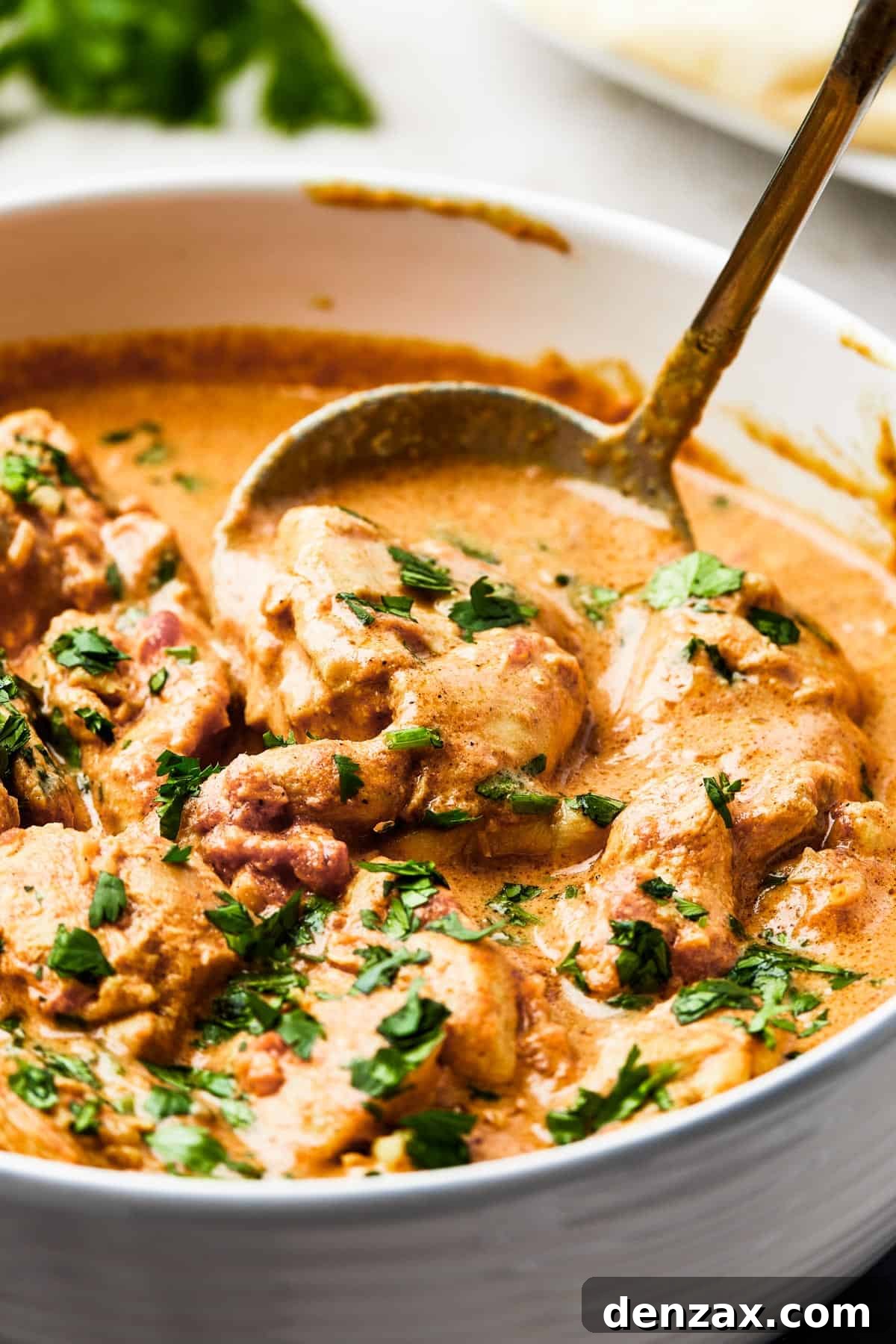 Butter Chicken Makhani 10 Close-up of tender chicken in a vibrant orange butter chicken sauce.