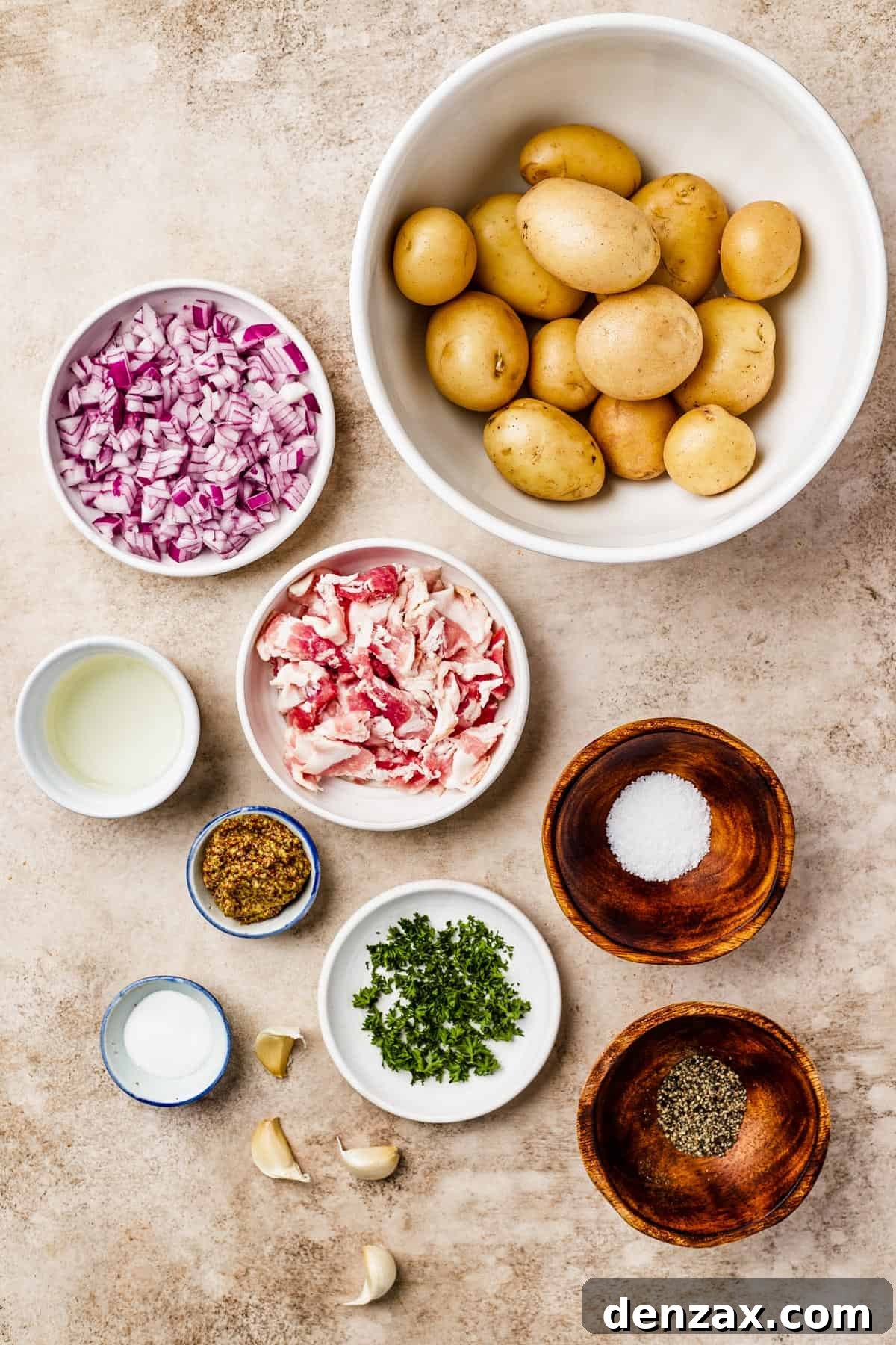 From top: Whole yellow potatoes, finely chopped red onion, white wine vinegar, crispy chopped bacon, whole grain mustard, salt, sugar, minced garlic, fresh parsley, and black pepper – all key ingredients for this flavorful salad.