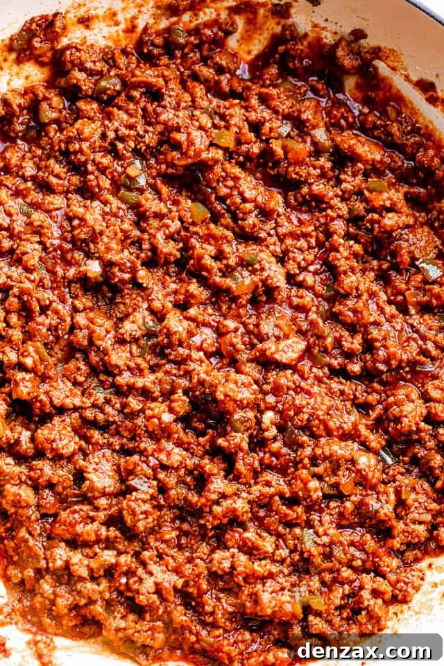 Ground beef in a skillet mixed with ketchup and brown sugar.