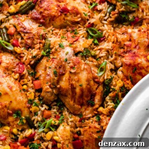 Overhead shot of a round casserole dish with ranch chicken thighs, rice, and vegetables.