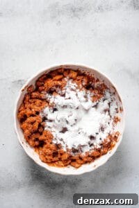 Puppy Chow 9 Powdered sugar dumped in a bowl of coated cereal.
