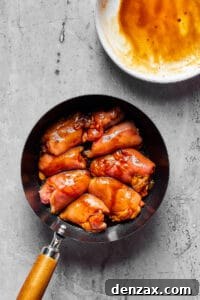 Chicken thighs cooking in a skillet.
