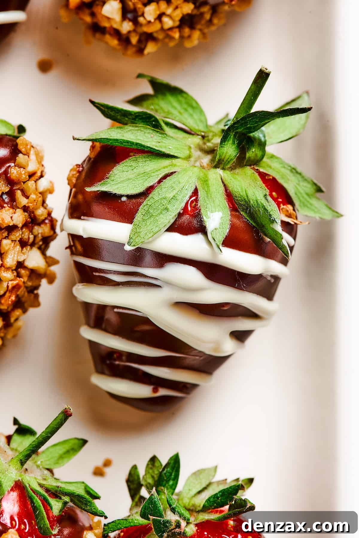 A perfectly dipped chocolate covered strawberry, elegantly drizzled with white chocolate, showcasing a gourmet finish.