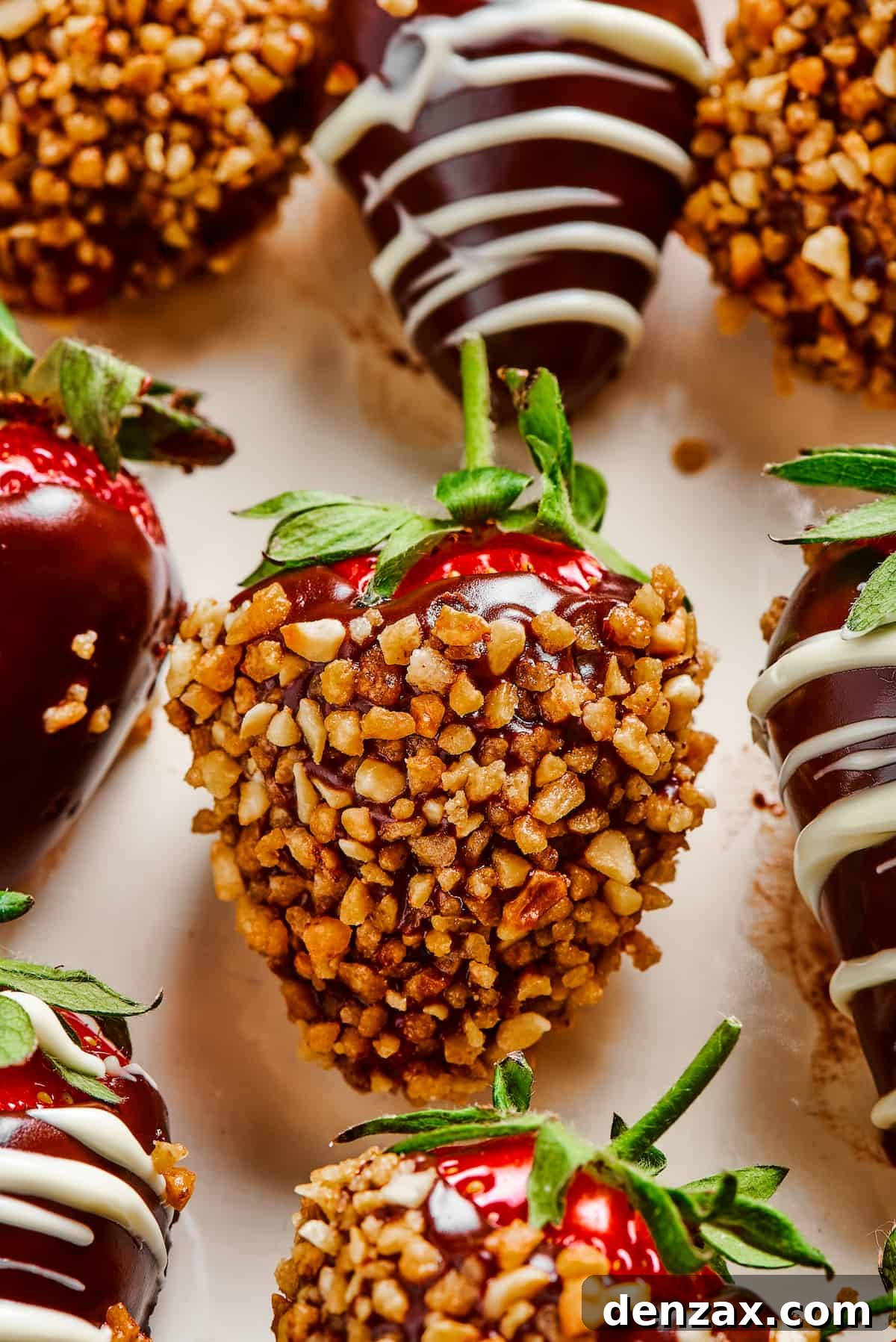 A decadent chocolate covered strawberry generously coated in chopped nuts, offering a delightful texture contrast.