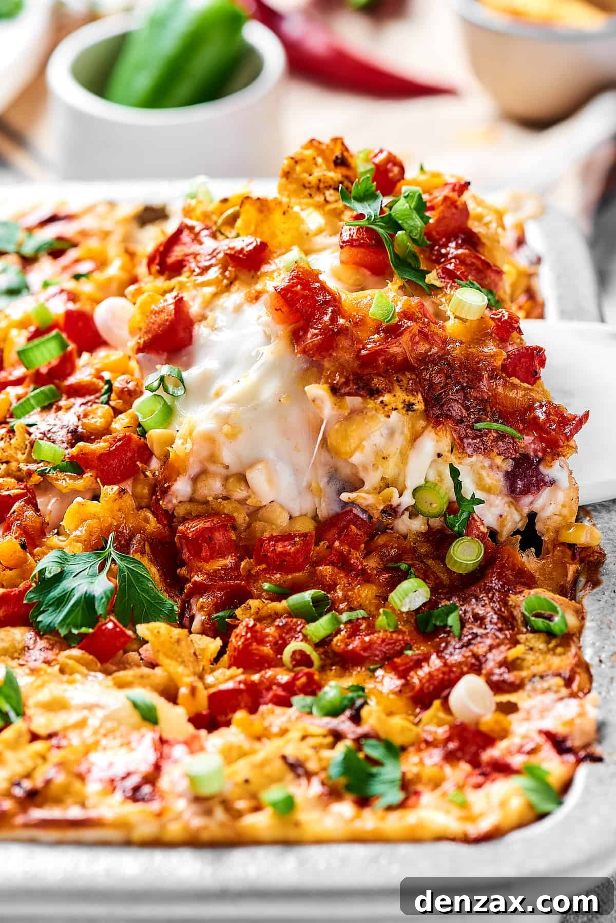 Close-up shot of a portion of casserole being lifted out of a baking dish.