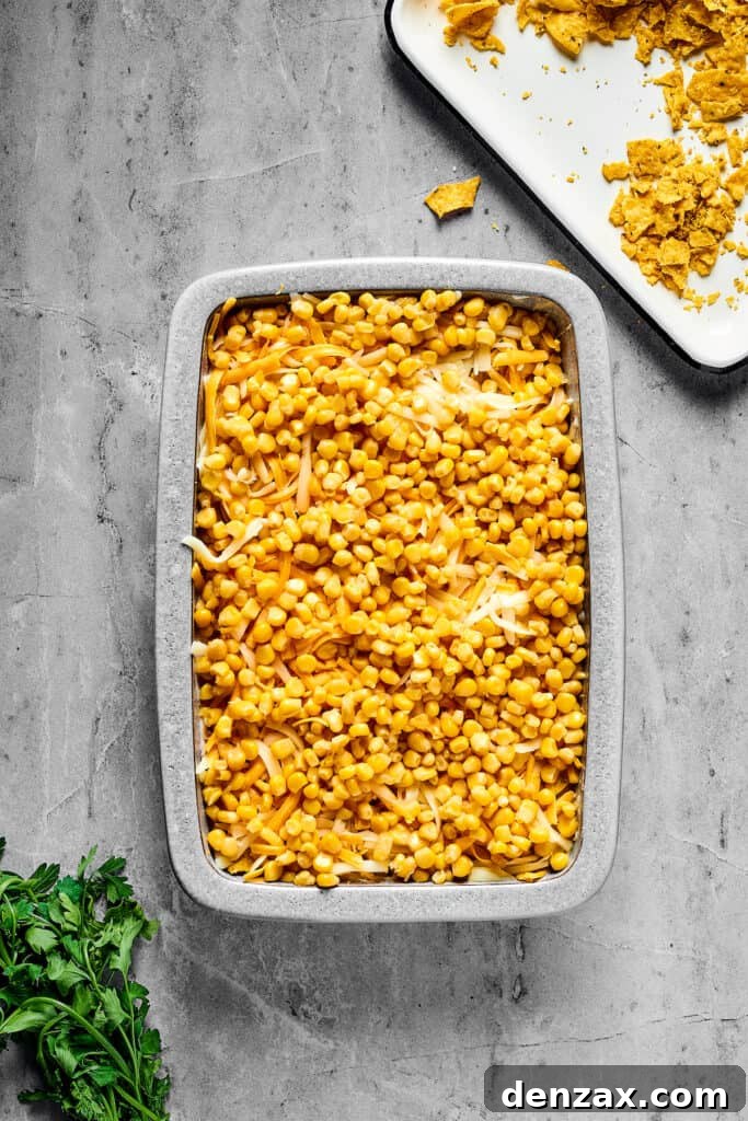 A baking pan with layers of ingredients inside. Corn is the top layer.