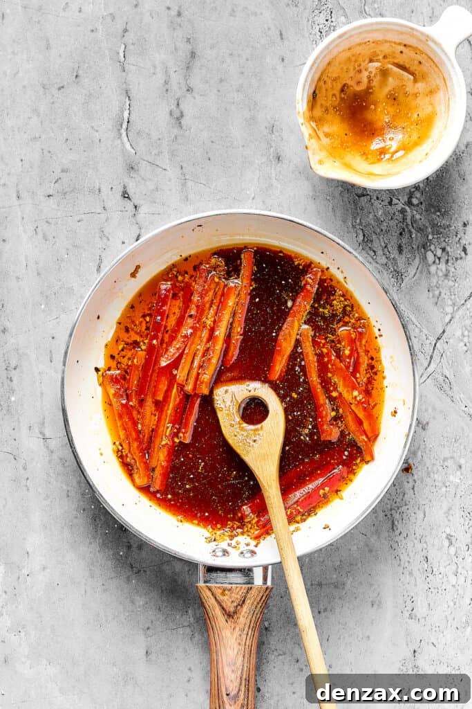 Bell pepper strips cooking in a skillet of reddish sauce.