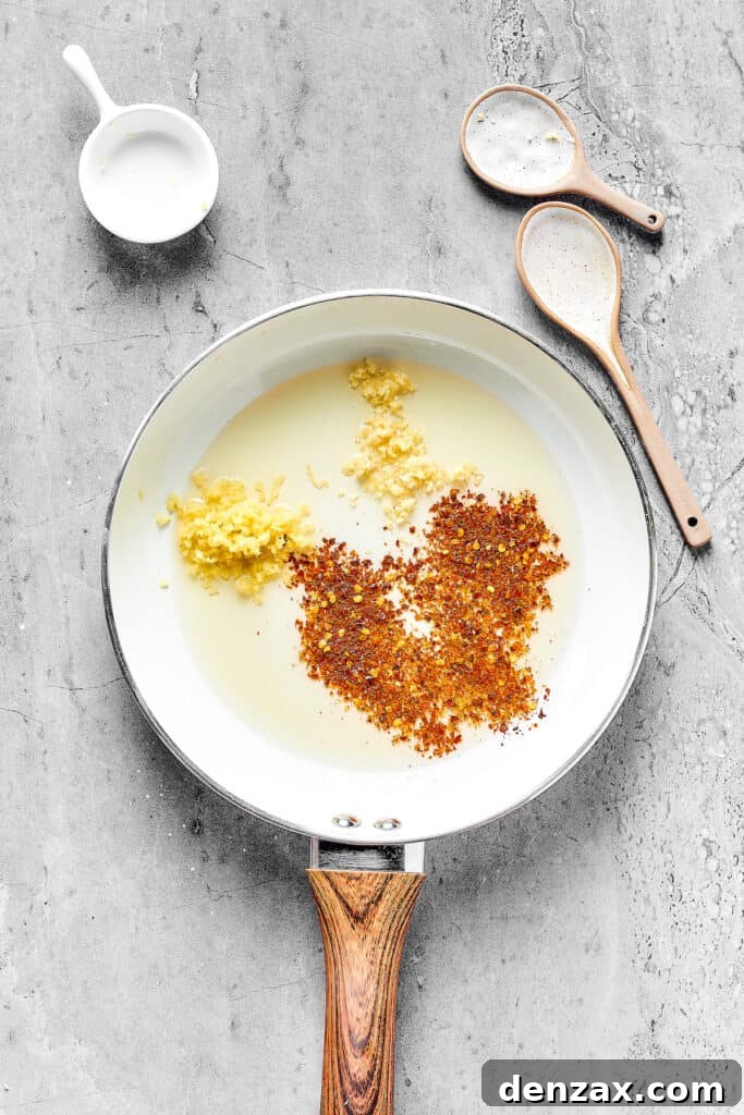 Spices and aromatics in a skillet.