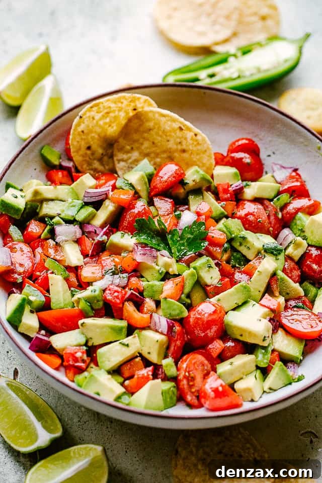 Freshly made avocado salsa served with golden tortilla chips and lime wedges, perfect for dipping.