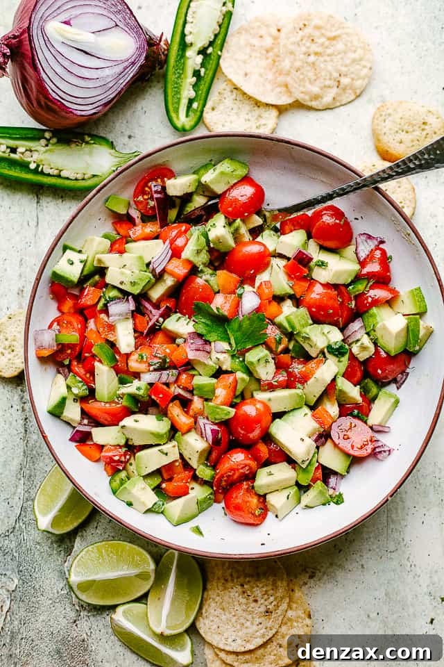 A beautiful bowl of homemade avocado salsa served with crunchy tortilla chips, ready for dipping.