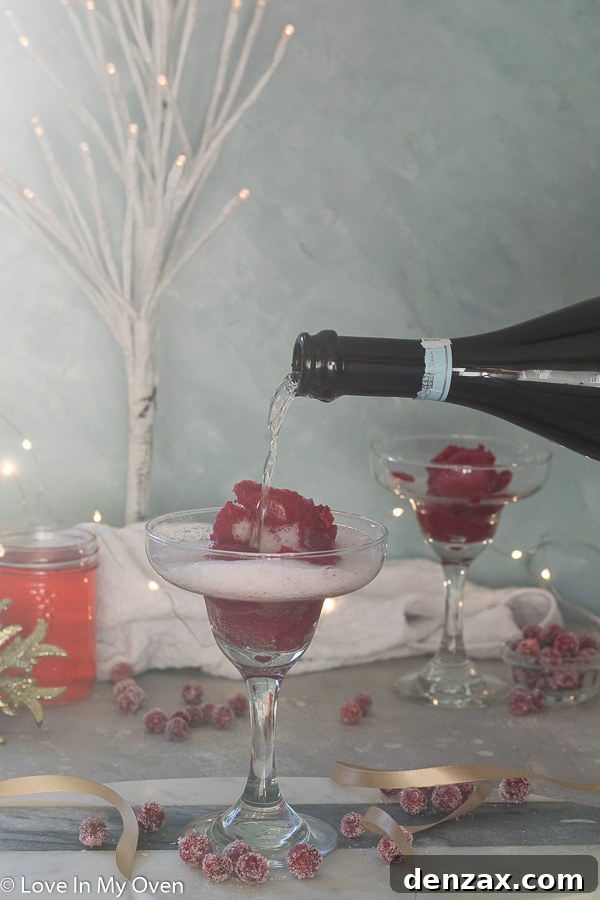 Two Cranberry Sorbet Champagne Floats garnished with fresh cranberries and rosemary.