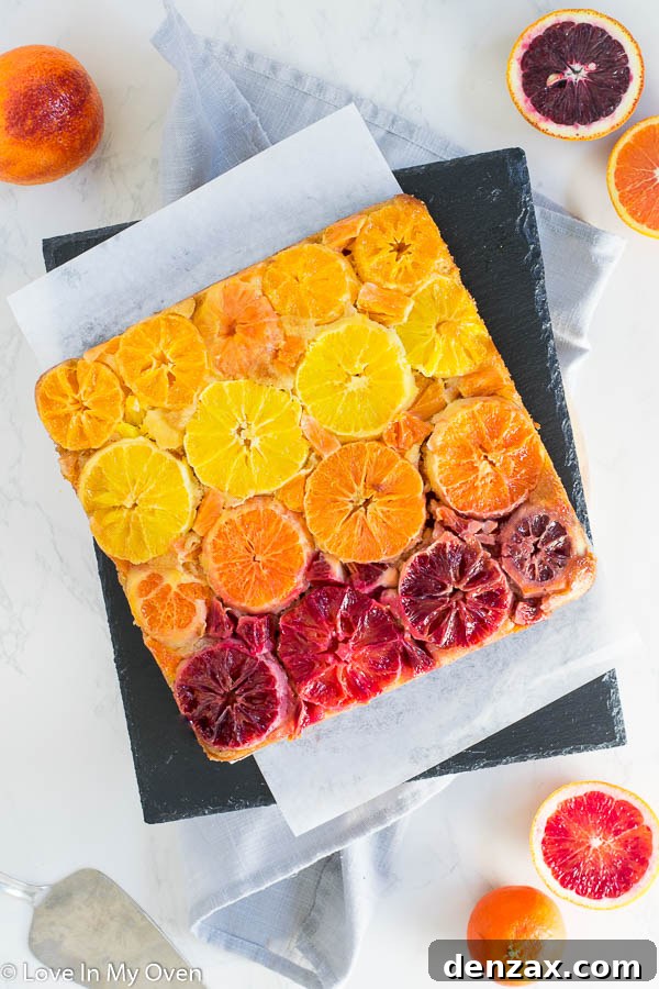 Vibrant orange upside down cake adorned with colorful citrus slices, showcasing the beauty of a triple citrus cake recipe.