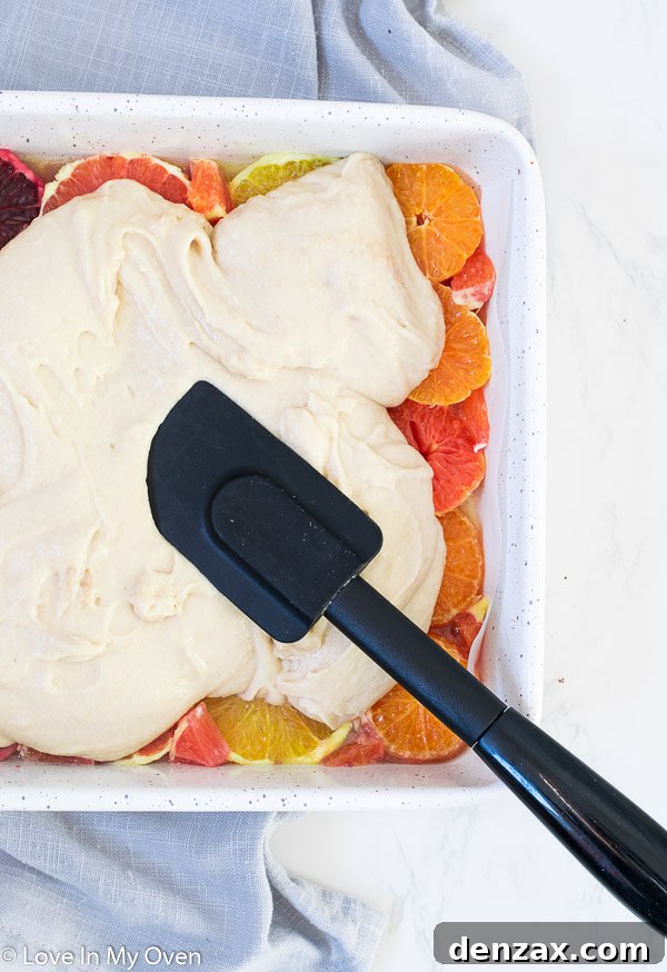Parchment paper lining an 8x8 baking pan, with edges overhanging, preparing for an orange upside down cake.