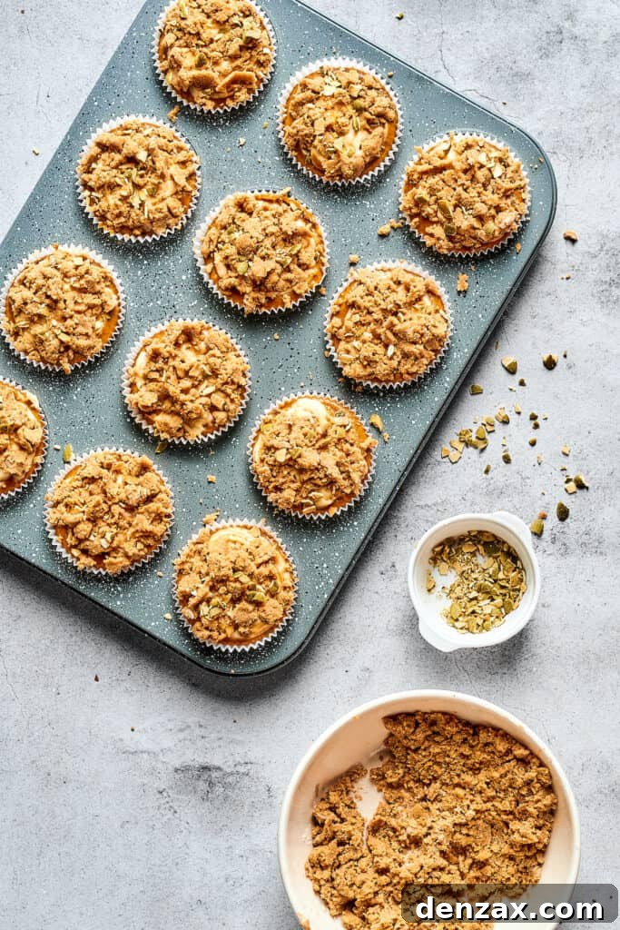 Muffins in a tin, topped with crumbly streusel.