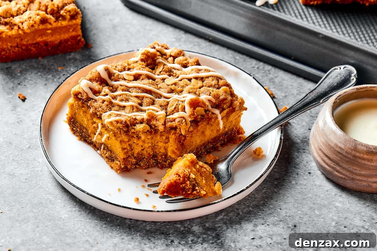 A single pumpkin cheesecake bar on a small white dessert plate, accompanied by a fork, ready to be enjoyed.